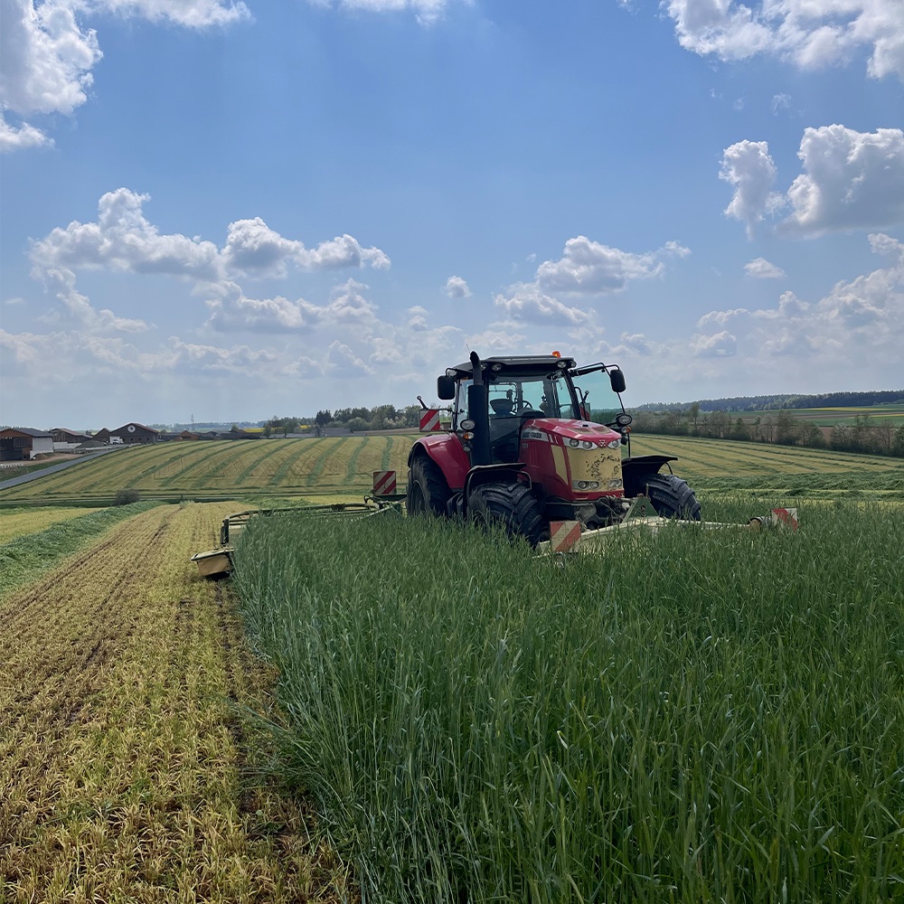 Traktor bei der Feldarbeit auf den biologisch bewirtschafteten Ackerflächen des Hofs